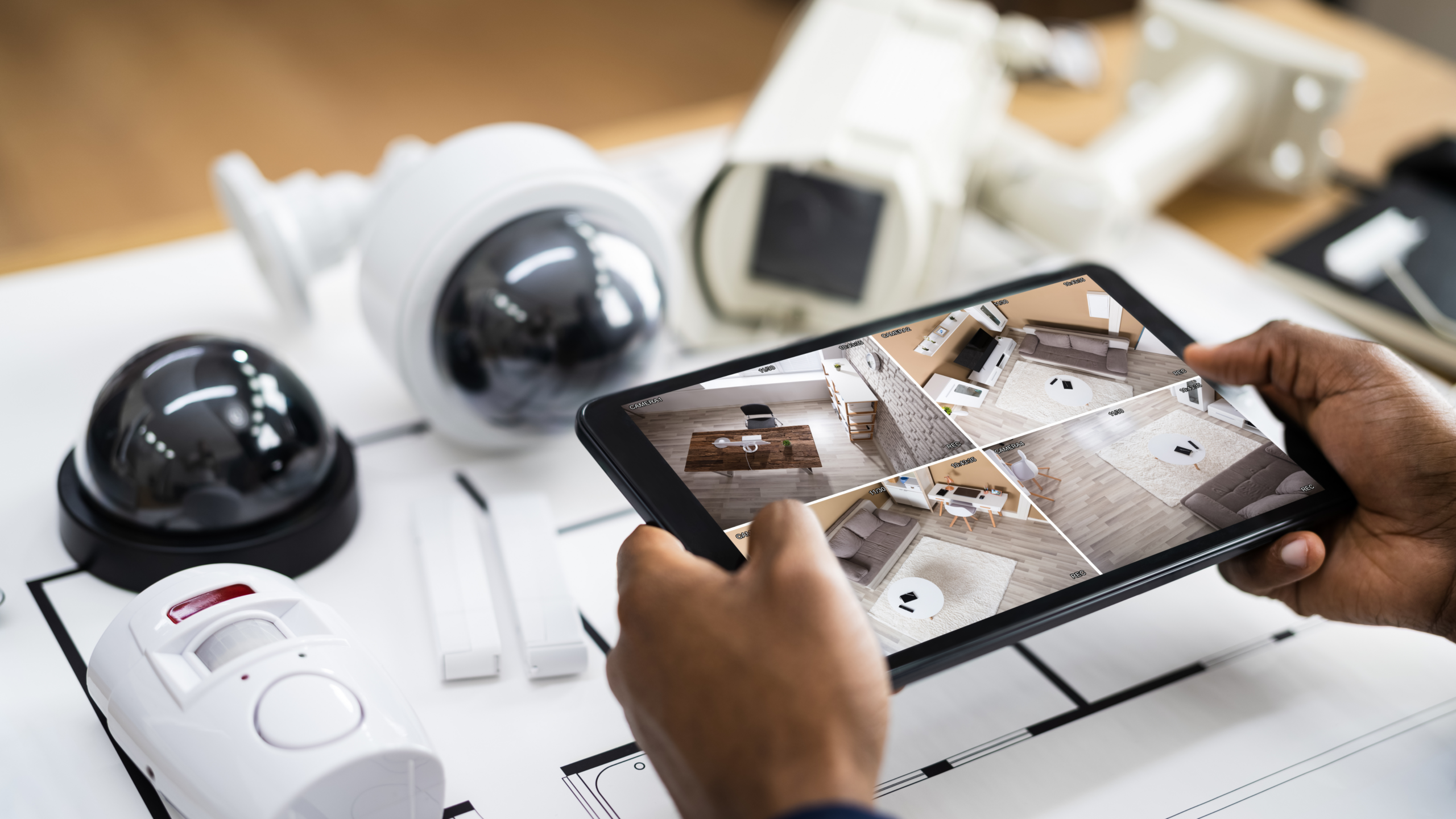 Hand holding iPad and monitoring Video Surveillance Cameras